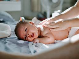 Dieses Bild zeigt ein Baby, dass massiert wird.